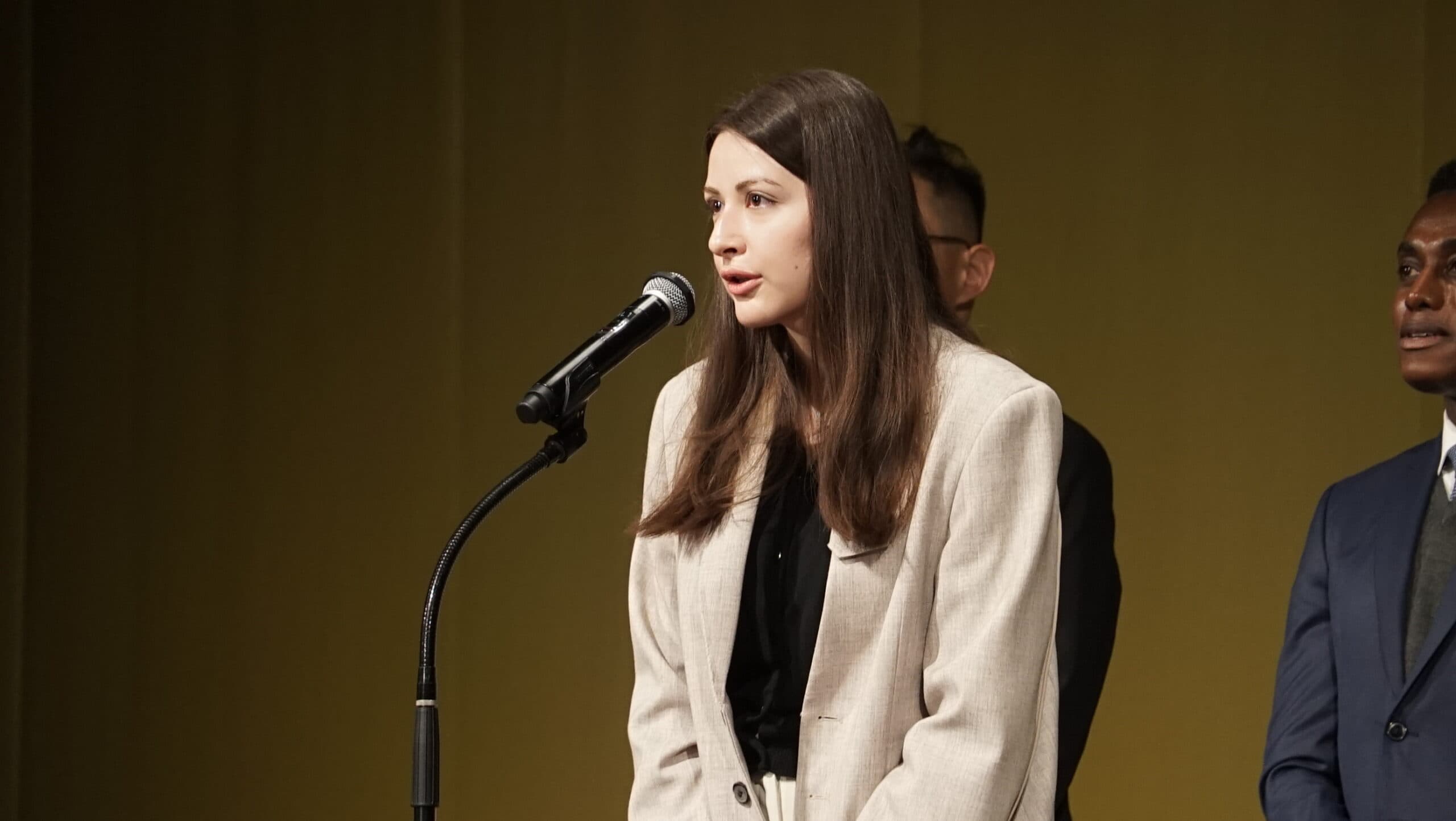 A student giving a speech at the microphone during the entrance ceremony in Tokyo