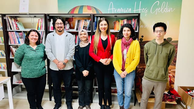 Edusama team and Nevşehir Hacı Bektaş Veli University staff posing together in front of bookshelves